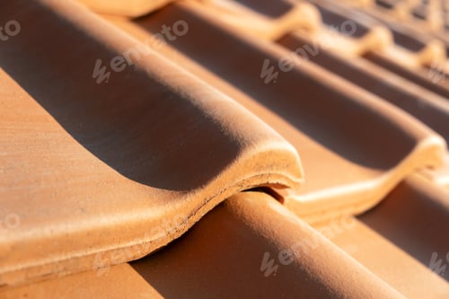 Preview: Overlapping rows of yellow ceramic roofing tiles covering residential building roof