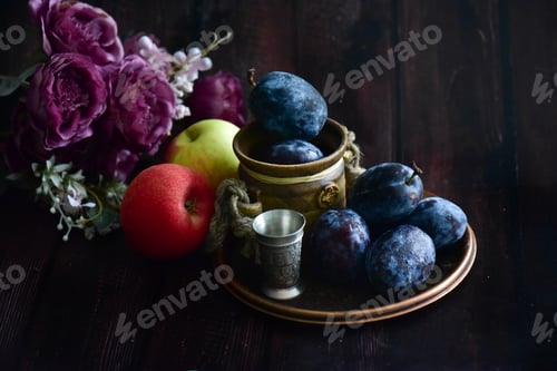 Preview: Apples and plums with flowers on a table