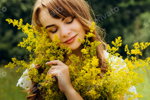 Vorschau: Sommerliches Lifestyle-Porträt einer schönen jungen Frau im Kranz aus wilden Blumen.