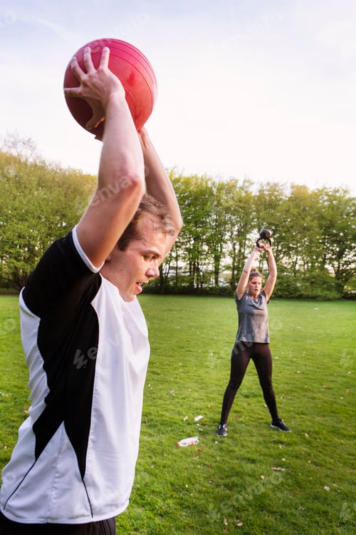 Preview: People exercising on grassy field at park