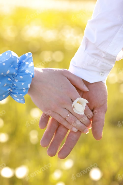 Preview: romantic date concept. young man and woman hands holding each other. girl with golden ring on finger