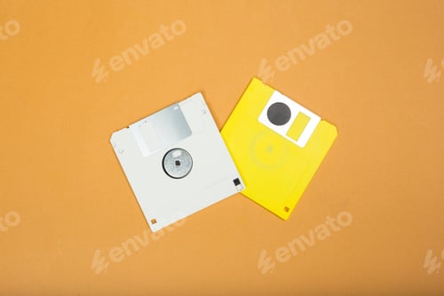 Preview: Old floppy disks placed on a plain orange background during the day