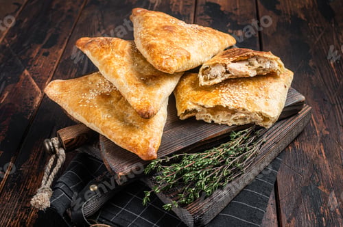 Preview: Baked samosa with chicken and cheese, samsa pies. Wooden background. Top view