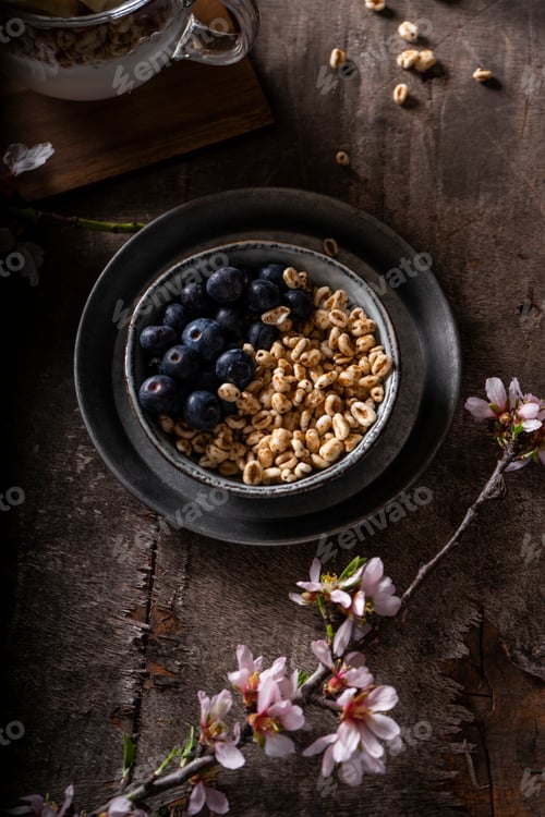 Preview: granola and fresh blueberries, in metal bowl on old wooden background. Vintage effect.