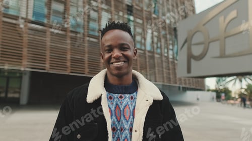 Preview: Close up, guy student stands outside the university building looks at the camera and smiles