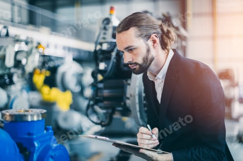 Preview: Businessman manager in suit working in machinery factory robot assembly plant