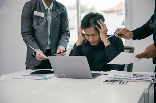 Preview: A man is sitting at a desk with a laptop and papers in front of him