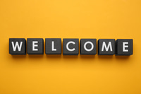 Preview: Word Welcome made of black cubes on yellow background, top view
