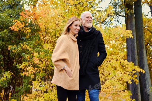 Preview: Cheerful granddaughter and grandfather on walk in autumnal wood