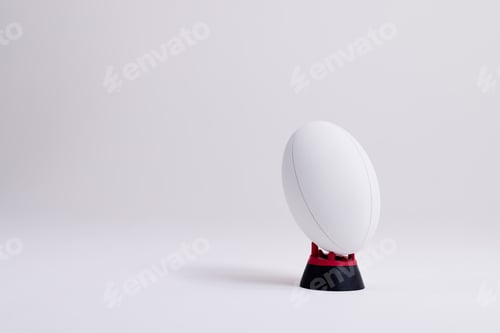 Preview: White rugby ball on red and black stand with copy space on white background