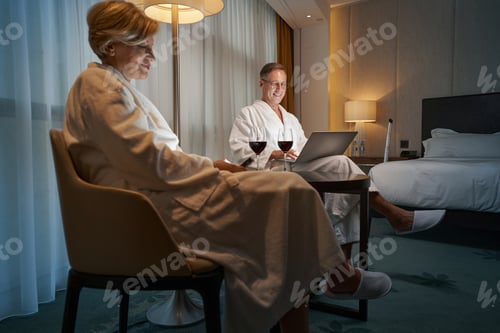 Preview: Pleased business partners relaxing and working remotely from hotel