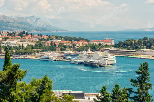 Preview: Coastal town of Split with a marina under clear skies, featuring moored ferries,