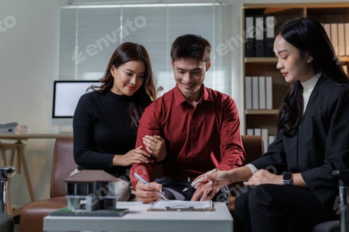 Preview: Asian couple signing real estate purchase contract with agent