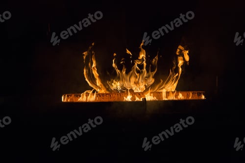Preview: Closeup shot of a red hot iron with flames with a black background