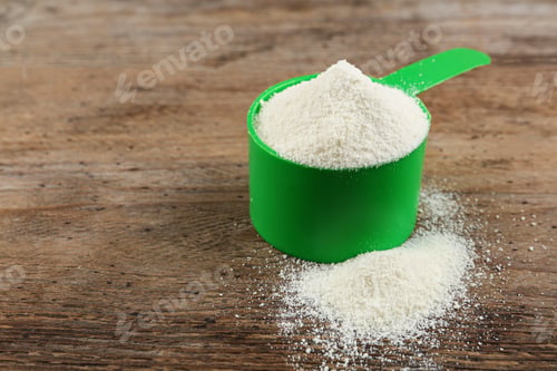 Preview: Measuring scoop of protein powder on wooden table. Space for text