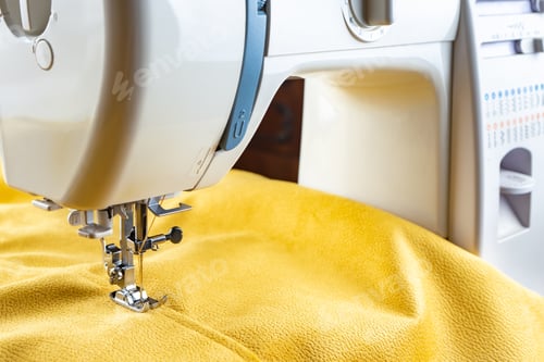 Preview: Modern sewing machine and yellow fabric. Sewing process, handmade, hobby, DIY, business, repair