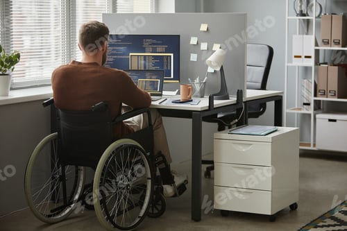 Preview: Back View Man with Disability as Programmer Writing Code in Office