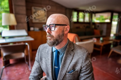 Preview: Modern man with beard and glasses in herringbone suit