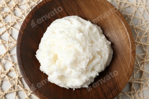 Preview: Shea butter in wooden bowl on wicker mat, top view