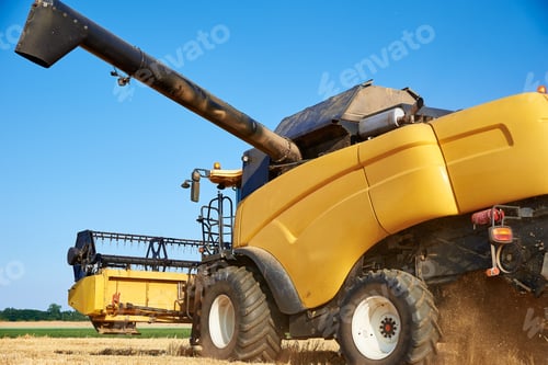 Preview: Combine harvester harvesting golden ripe wheat in agricultural field