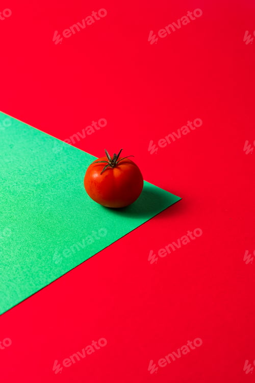 Preview: organic Vibrant tomato on a bold green and red diagonal split background, italian pasta concept