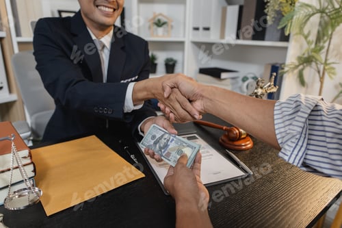 Preview: An unethical act of bribery showing hands exchanging cash in a law office environment