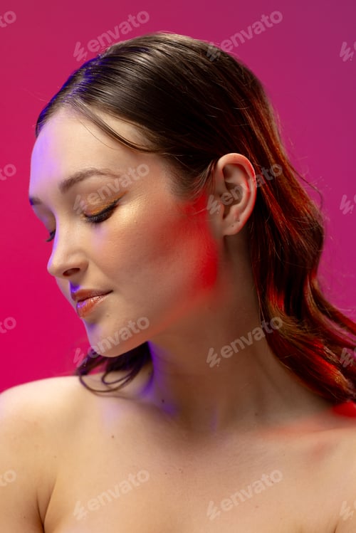 Preview: Caucasian woman wearing eyeliner and lip gloss on pink background