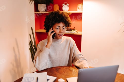 Woman in glasses speaks on phone and solves work problems. Girl working in laptop