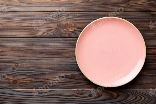 Preview: Top view of empty pink plate on wooden background. Empty space for your design