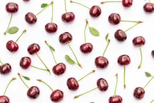 Preview: Cherry pattern. Flat lay of cherries and leaves on white background.