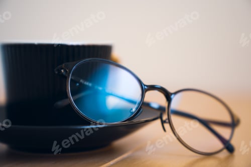 Preview: Morning cup of coffee with glasses on a wooden table