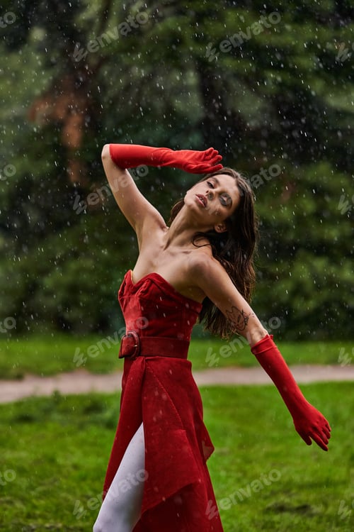 Preview: Ethereal euphoria: woman in red dancing in rain