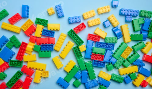 Preview: Multi-colored plastic cubes of a children's designer on a blue background, top view