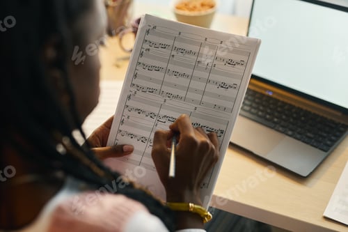 Visualização: Escrevendo notas musicais em uma mesa com um laptop