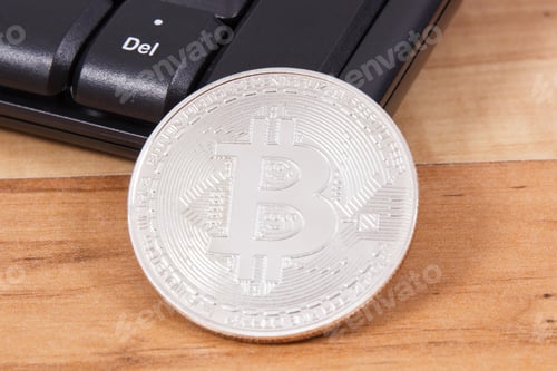 Preview: Silver bitcoin and computer keyboard as symbol of mining cryptocurrency