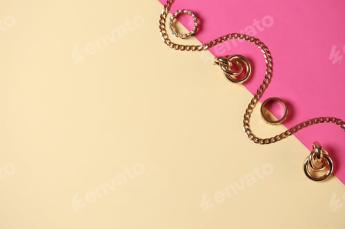 Preview: Stylish gold jewelry on color background, flat lay. Space for text