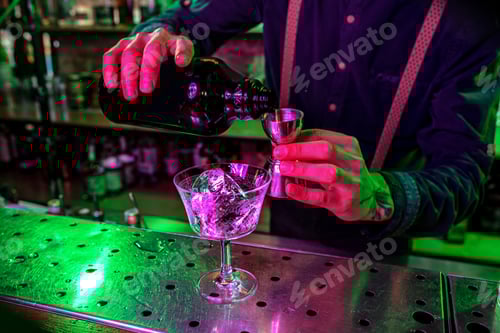 Preview: Close up of barman finishes preparation of alcoholic cocktail, pouring drink with shot in