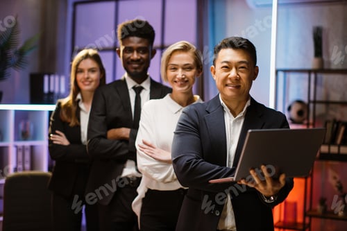 Preview: Multiethnic happy company workers standing in a row in creative office, posing on camera