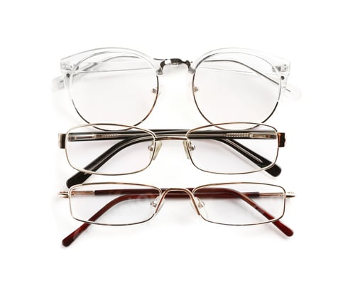 Preview: Different glasses with corrective lenses on white background. Vision problem