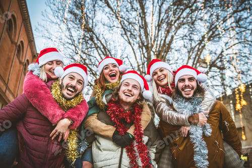 Preview: Happy group of friends wearing santa claus hat celebrating Christmas night together