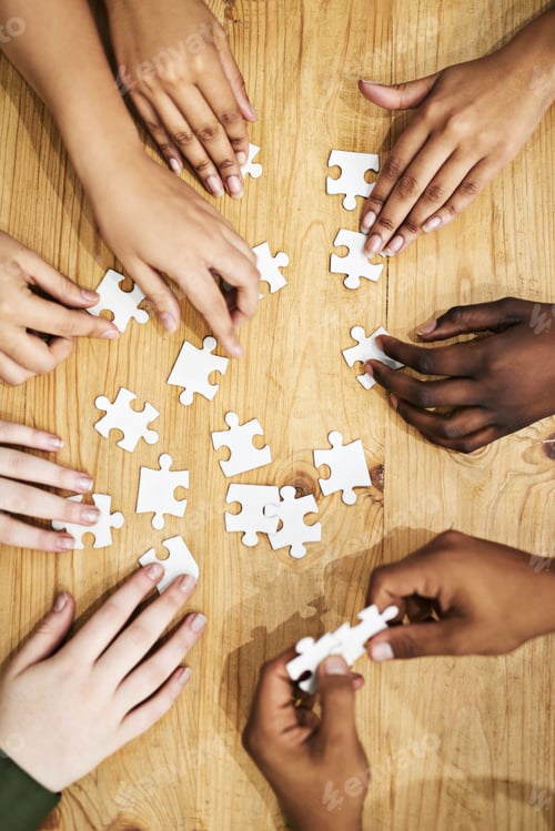 Preview: Problem solving like pros. Shot of a group of people building a puzzle together.