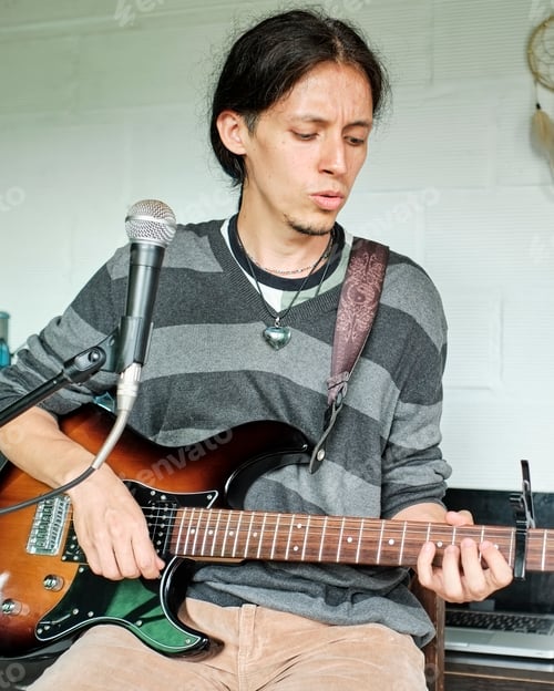 Preview: Musician singing and playing a guitar at home