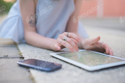 Preview: Young woman outdoor using tablet