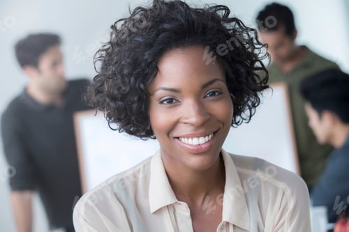 Preview: Confident woman smiling with colleagues in the background