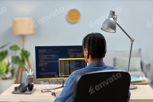 Preview: Male IT professional writing code while working at office workplace