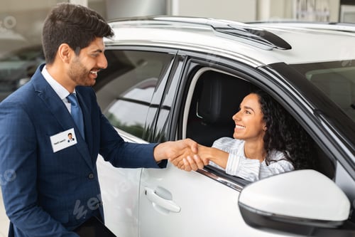 Preview: Happy business woman buying new luxury auto in showroom
