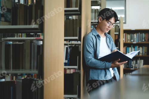 Preview: University students reading books in library for research.