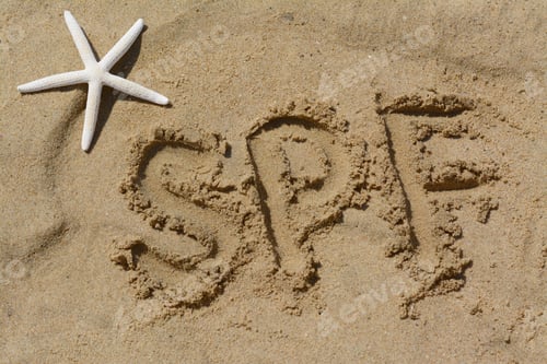 Preview: Abbreviation SPF written on sand and starfish at beach, above view
