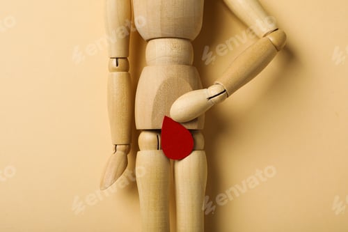 Preview: Menstrual cycle concept, wooden figurine of a man with a red drop