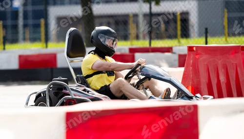 Preview: Man In Protective Helmet Driving Go-Kart By Racing Track